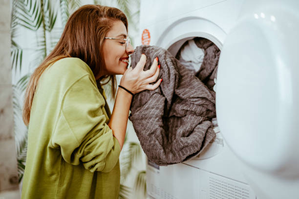 Chica oliendo ropa de secadora