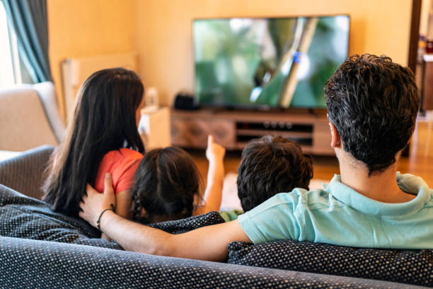 Una familia viendo la televisión de pantalla plana