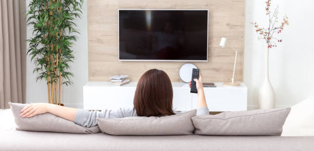 mujer viendo la TV en su salón