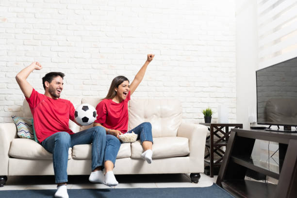pareja viendo un partido de fútbol en la TV