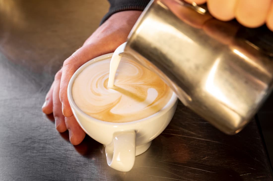 Barista sirviendo café en una taza
