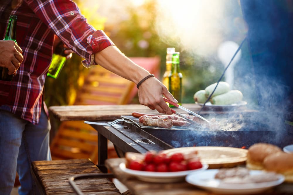 hombre asando carne en barbacoa