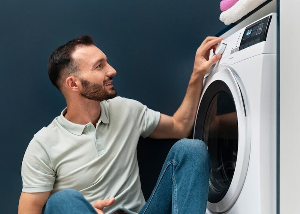 hombre feliz usando su lavadora de carga frontal