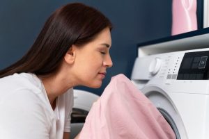 mujer oliendo ropa salida de la lavadora
