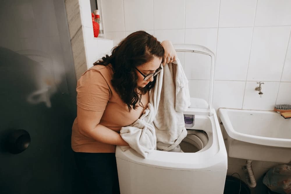 mujer usando lavadora de carga superior