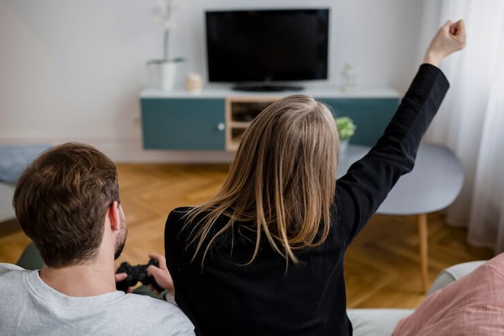 Parejas frente a la tv jugando videojuegos